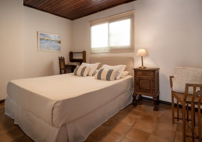 Dormitorio con cama, mesita de noche, escritorio y silla.
