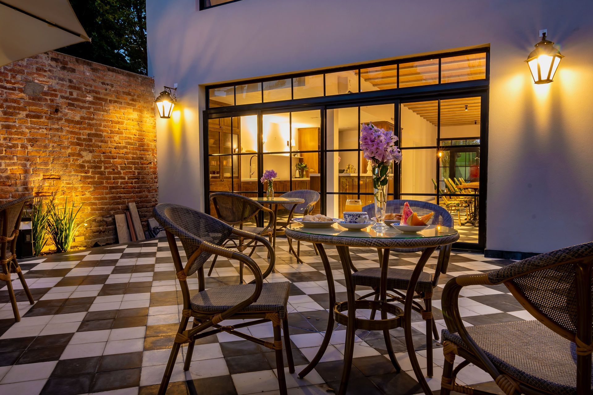 Patio con suelo de cuadros, sillas de mimbre