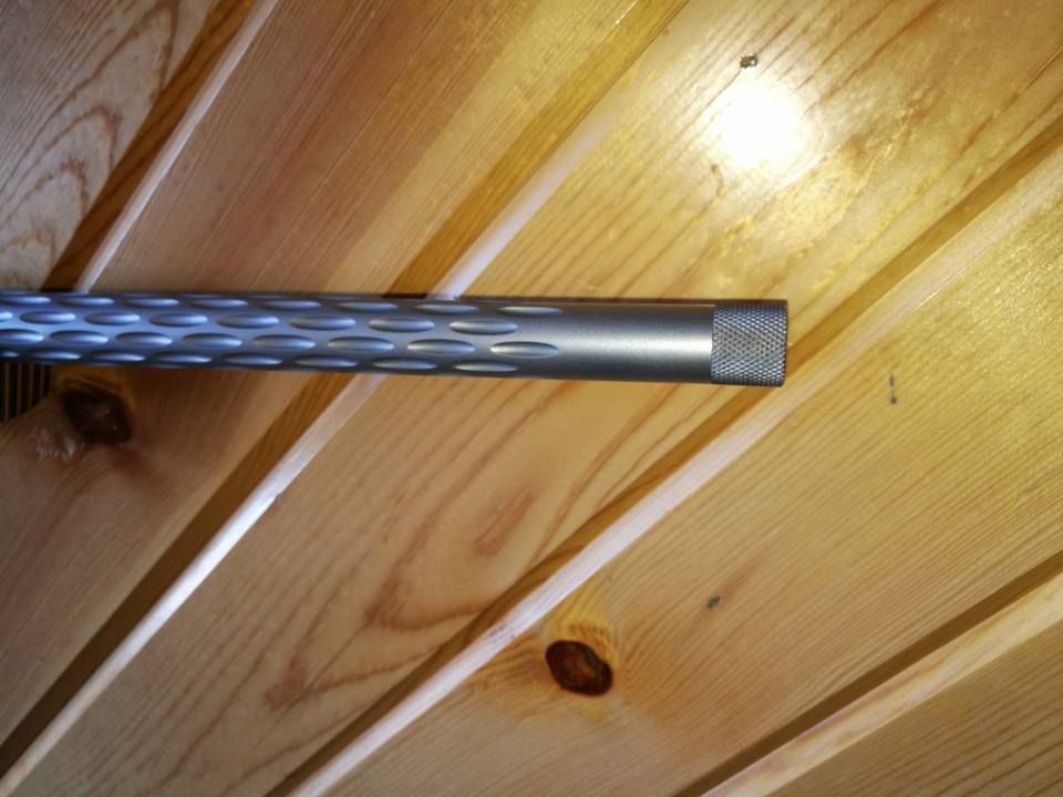 Blue braided metal rod resting against a light wooden plank wall