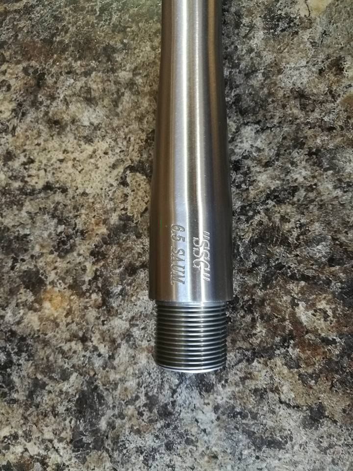 Stainless steel threaded metal rod segment on a speckled granite countertop