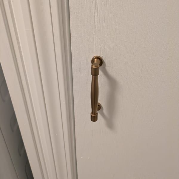 Brass pull handle on a white door near the frame