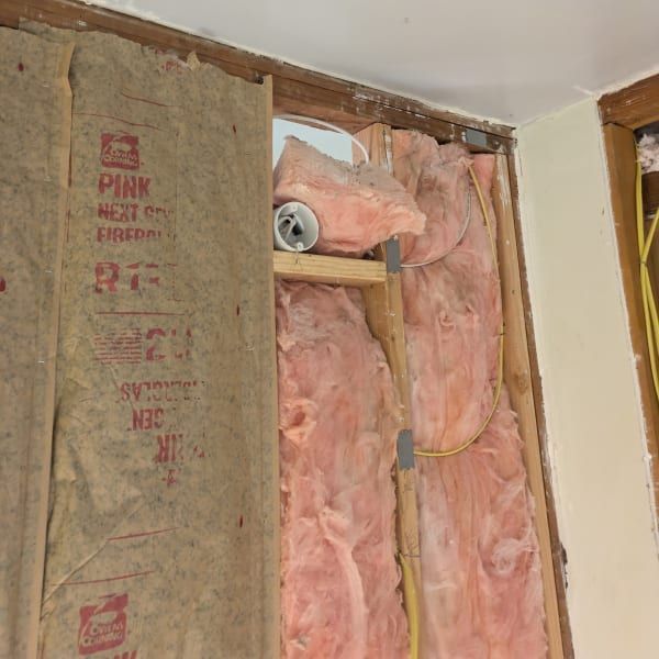Open wall with pink insulation and exposed studs during renovation