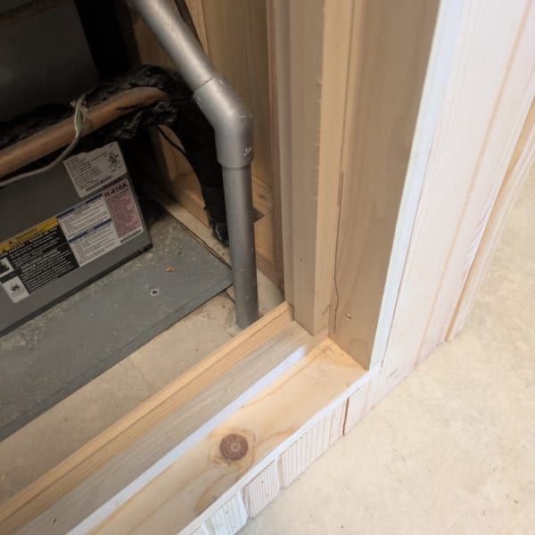 Open closet floor with exposed HVAC ductwork and a small wooden threshold strip