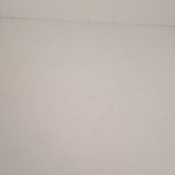 Blank off-white wall or ceiling with faint horizontal lines near the top.