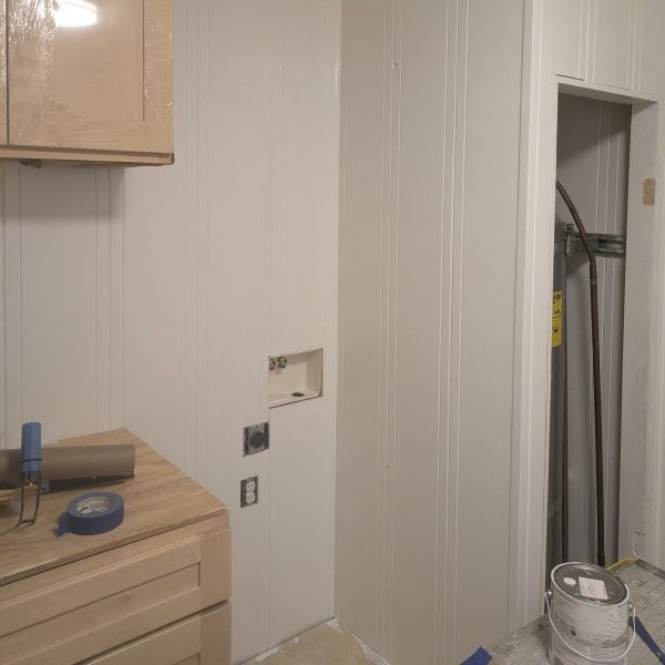 Bathroom wall with cabinet, countertop, and plumbing access panel cutout