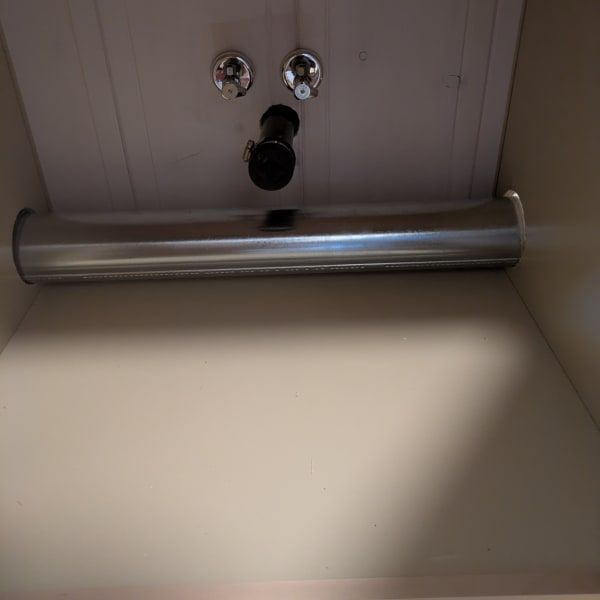 Chrome towel bar and wall-mounted fixtures above a beige wall panel.