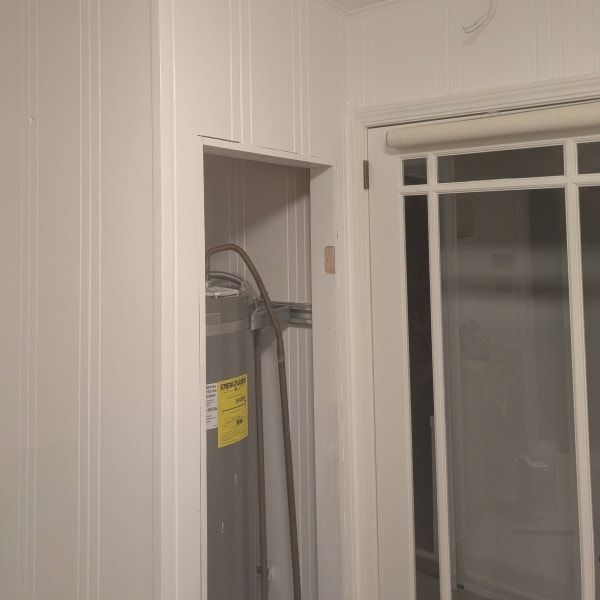 White interior wall with a narrow recessed closet and a glass-paned door or window beside it.