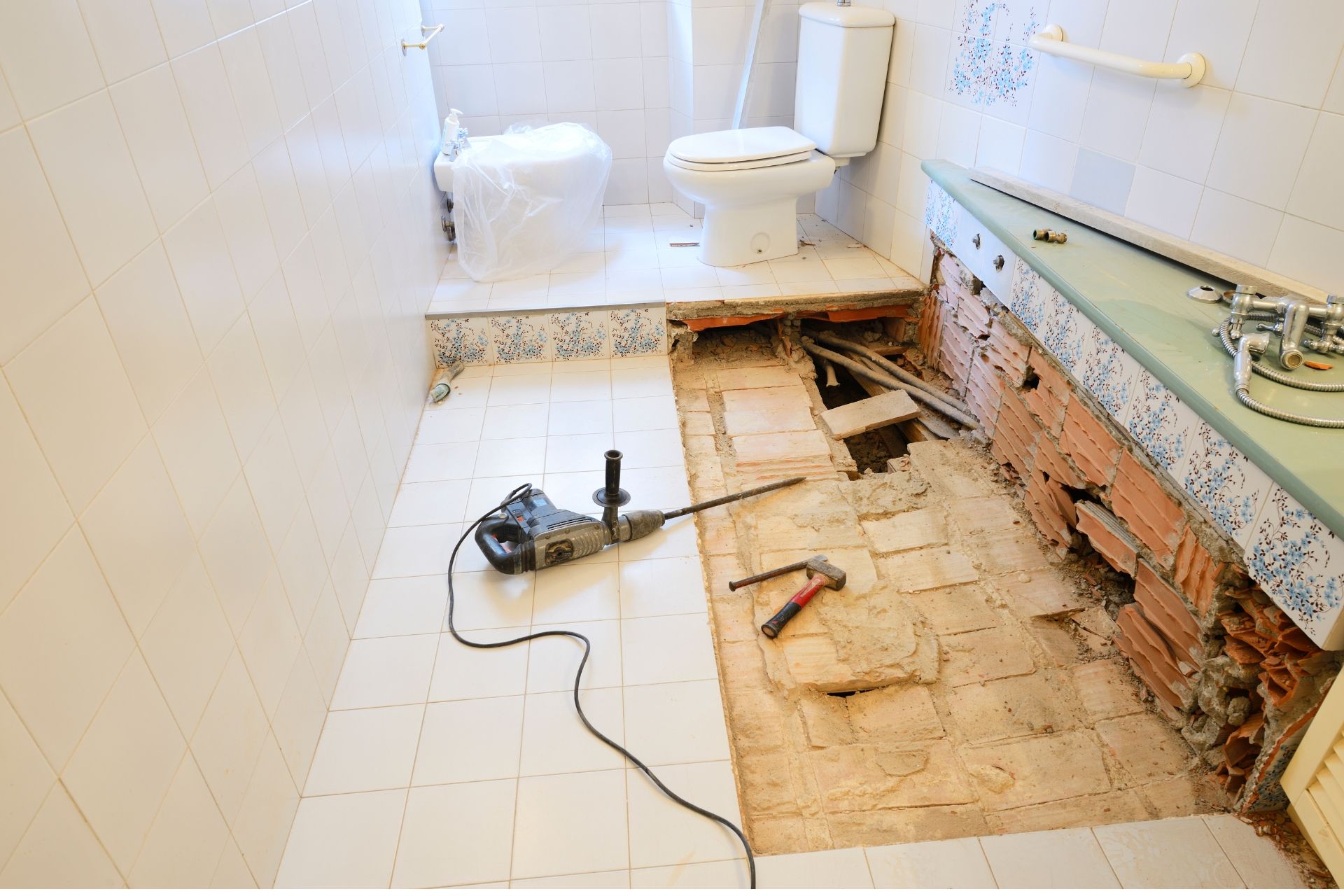 Bathroom under renovation with exposed floor and tools.