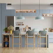Modern kitchen with blue cabinets, a wooden island, bar stools, and two hanging pendant lights