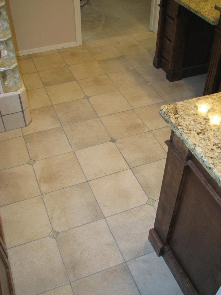 Kitchen floor with beige tile and dark wood cabinets beside a granite countertop.