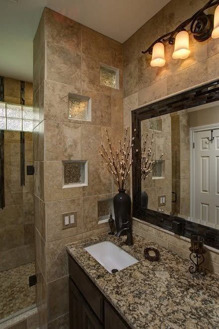 Small bathroom with granite vanity, stone-tiled wall, mirror, and three wall lights