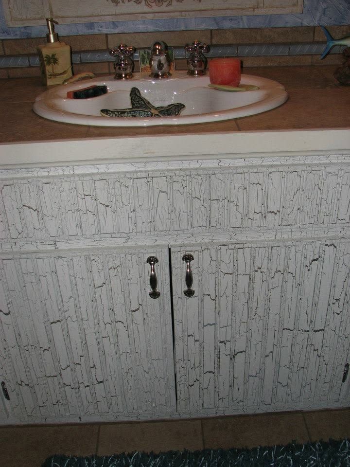 Bathroom vanity with white cabinet, sink, faucet, and decorative frog on the counter