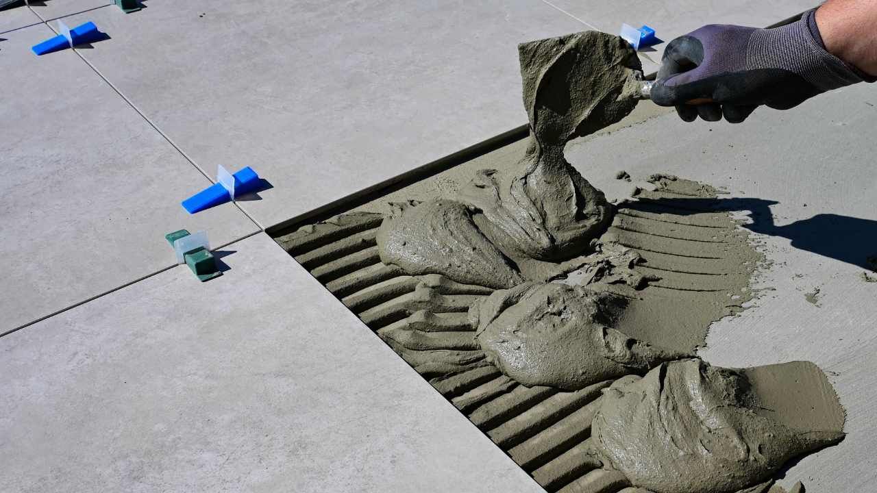 Worker spreading wet mortar with a trowel for block wall construction in Villa Park, CA
