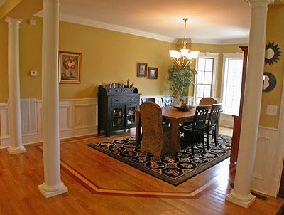 A dining room with a table and chairs and columns