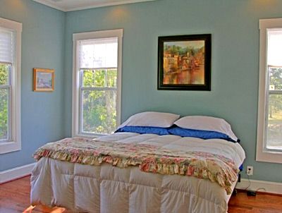 A bedroom with a bed and a painting on the wall