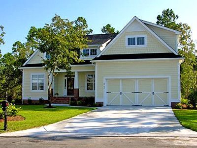 A large house with two garage doors and a driveway