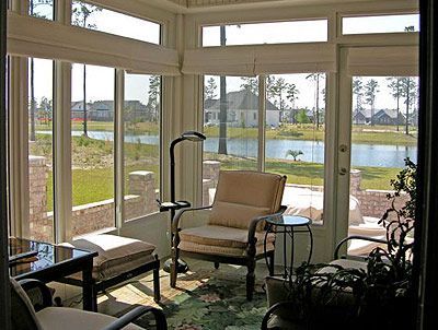 A living room with a lot of windows and chairs