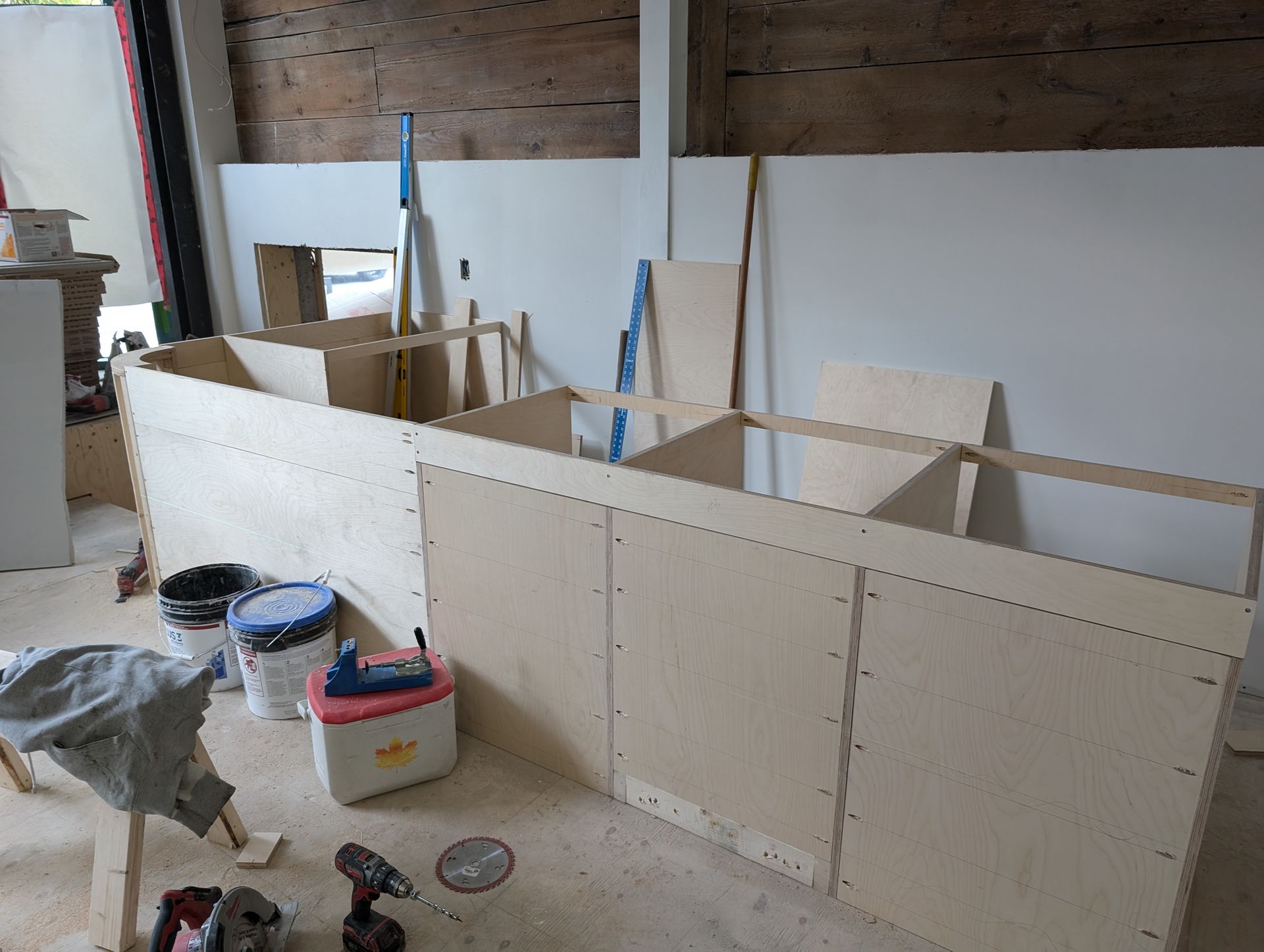 Construction à l'intérieur de structures d'armoires en bois, outils et fournitures à proximité.