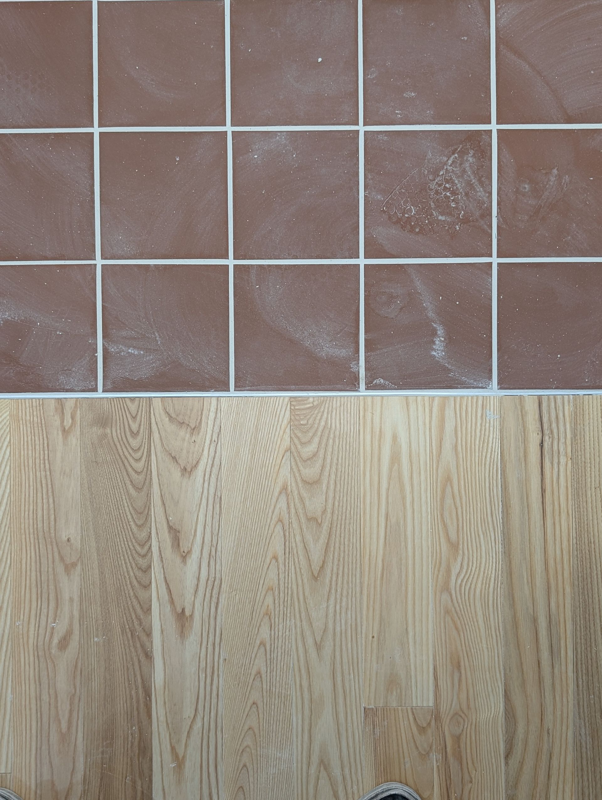 Le carrelage brun côtoie le parquet clair.