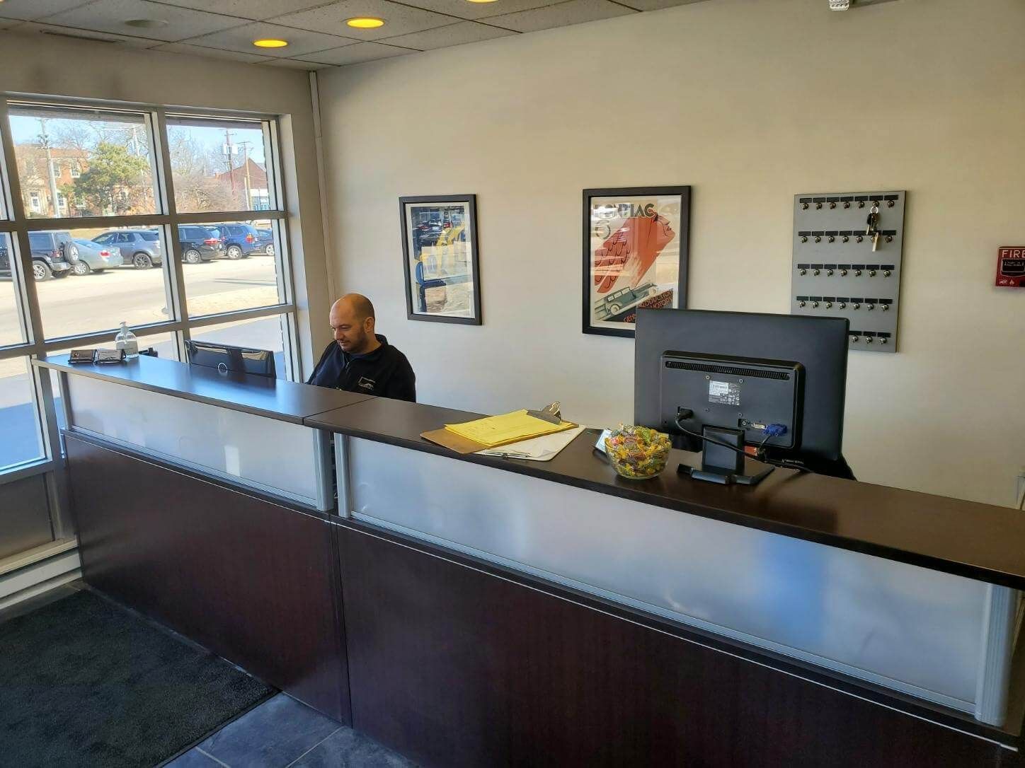 Reception Counter With Staff Assisting Customers In Service Office | J. Benak Service Inc.