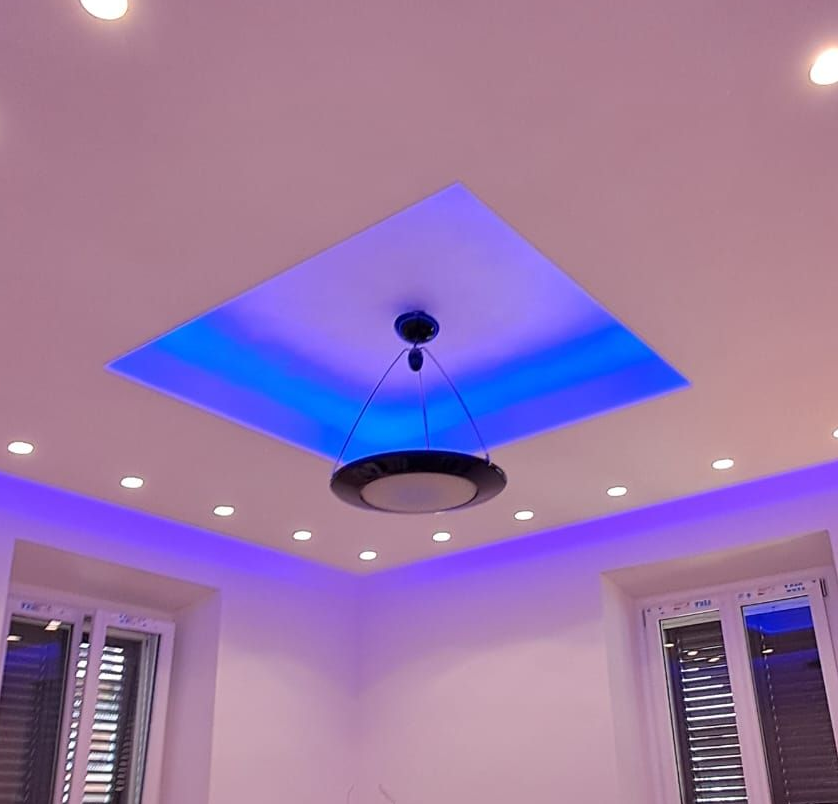 Parete del bagno parzialmente piastrellata con cablaggio, scatole elettriche e piastrelle del pavimento decorate.