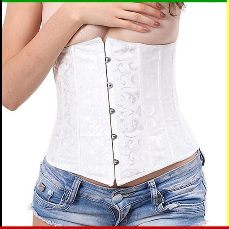 Witte corset over een spijkerbroekje, handen over de borst.
