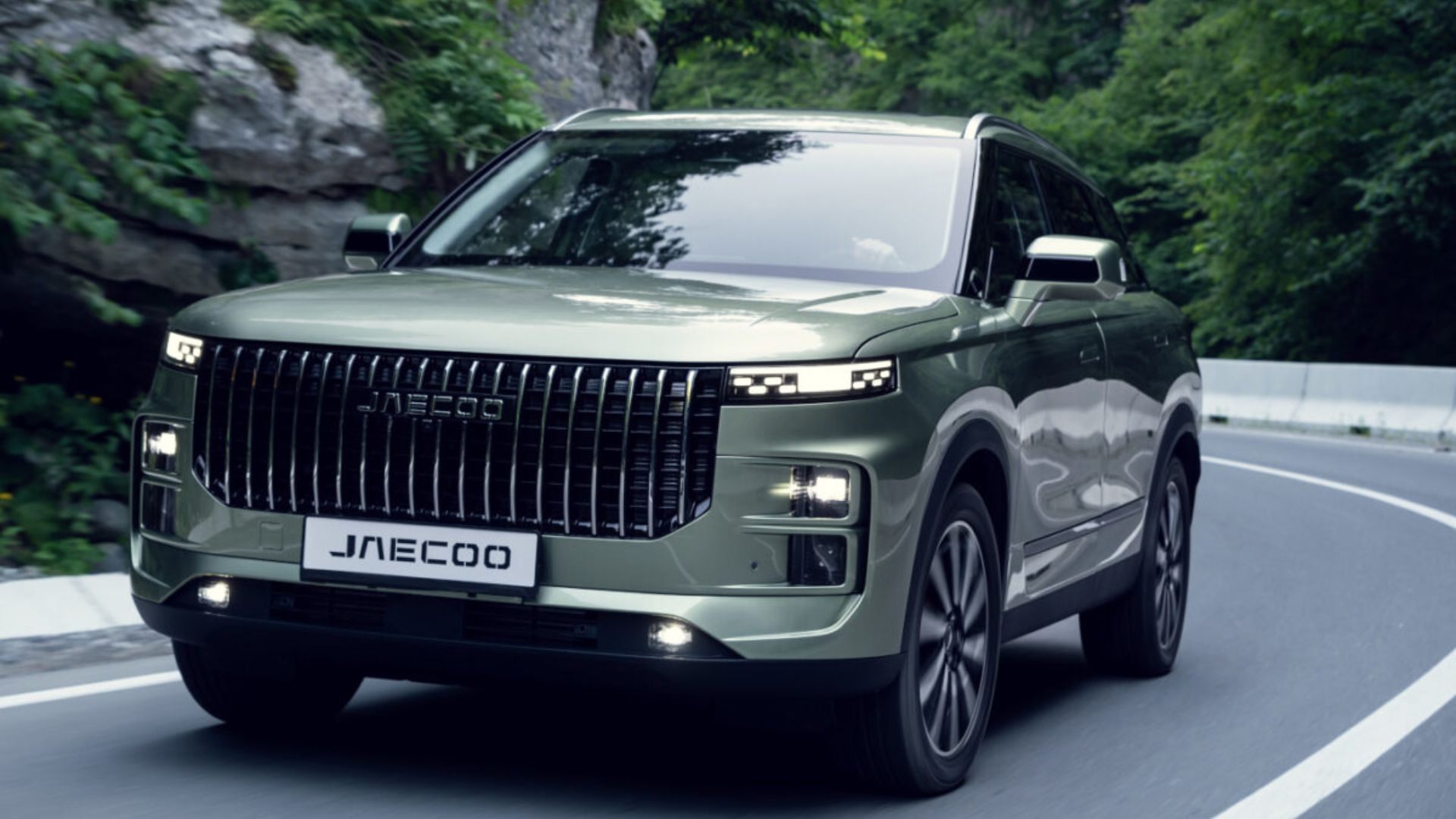 Green SUV driving on a winding forest road