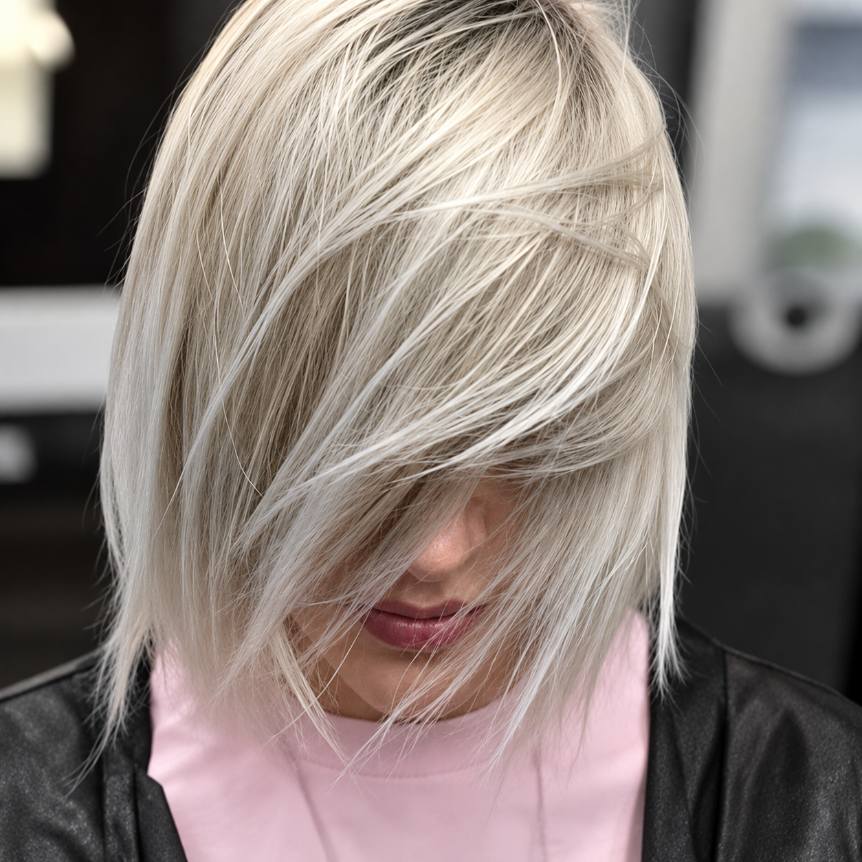 Foto del prima e dopo scattata in salone di una trasformazione di capelli biondi lisci, con radici più scure e punte più chiare.