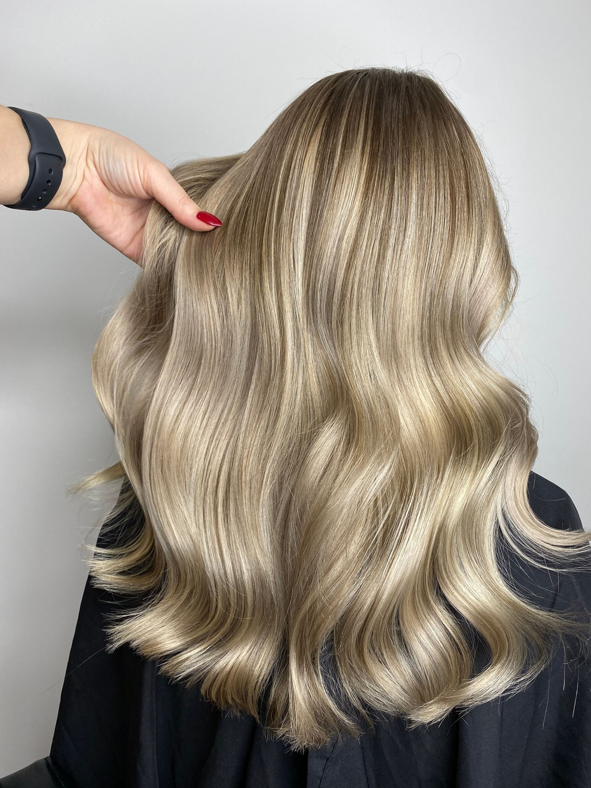 Lunghi capelli neri e lucenti visti da dietro in un salone di bellezza.