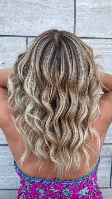 Primo piano di lunghi capelli lisci e lucenti, castani con riflessi ramati, tenuti da una mano.