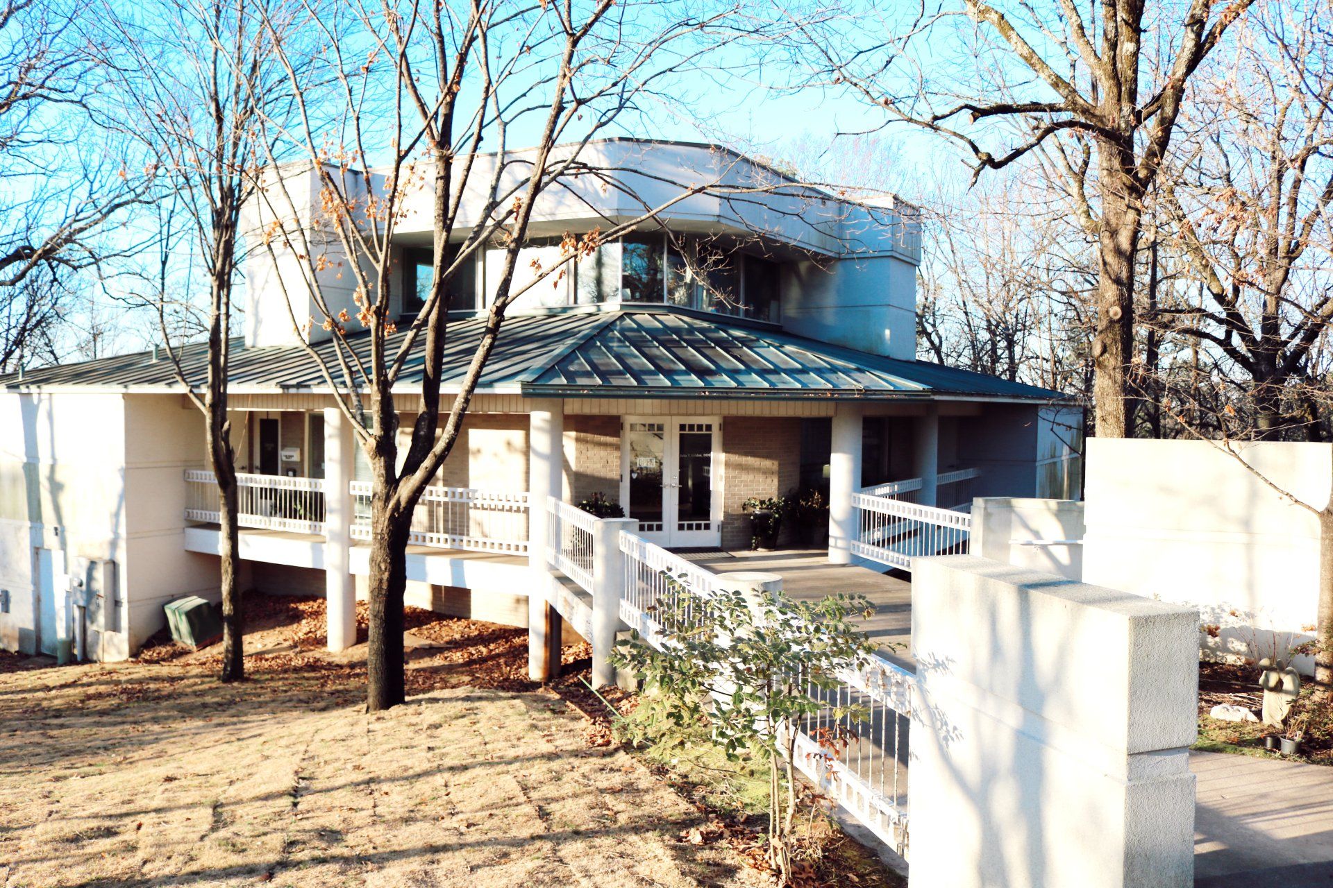 A white house with a blue roof and a white fence