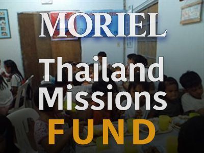 A group of people sitting around a table with the words moriel thailand missions fund