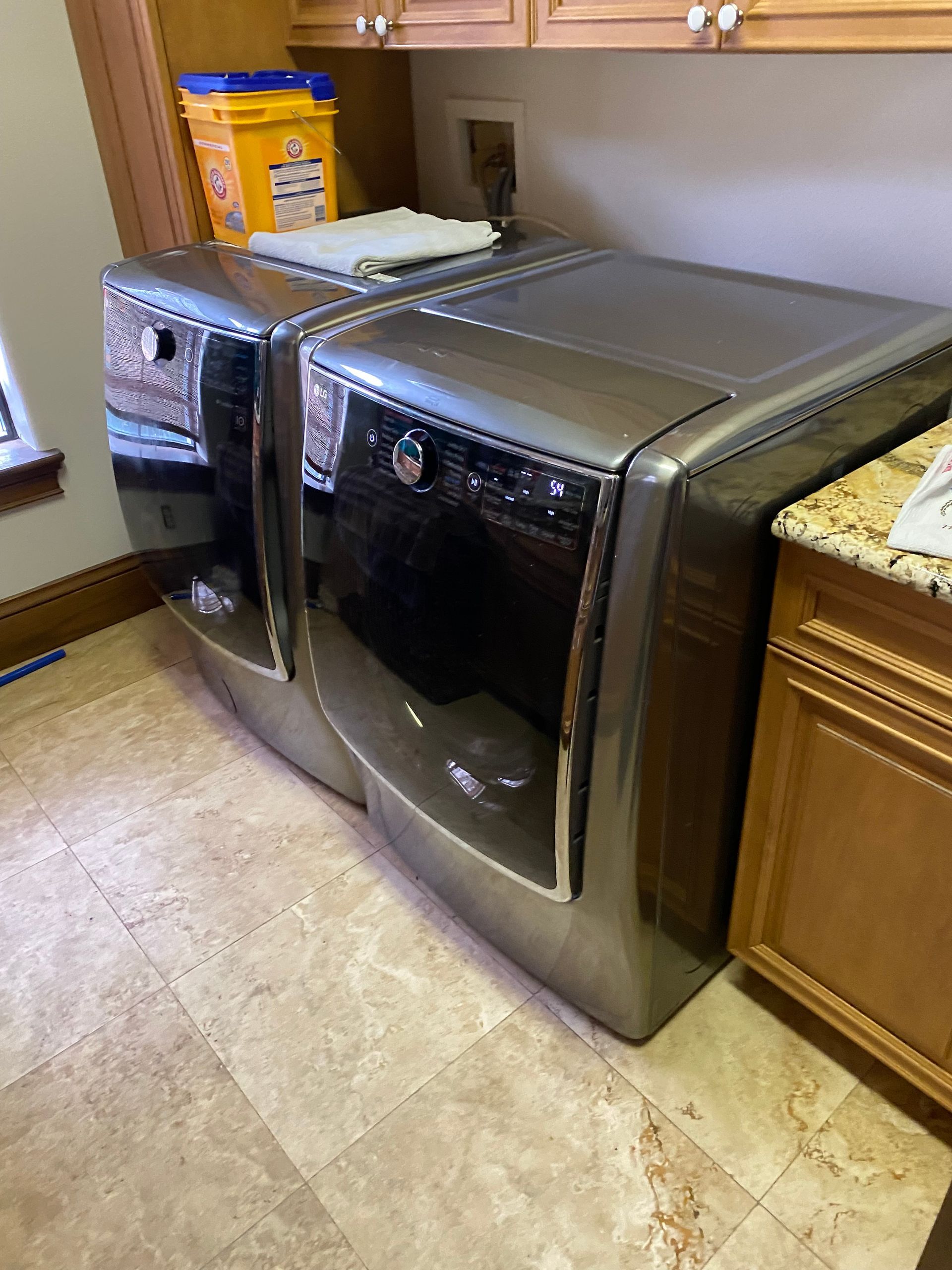 A pair of metallic-gray front-load washer and dryer appliances in a laundry room.