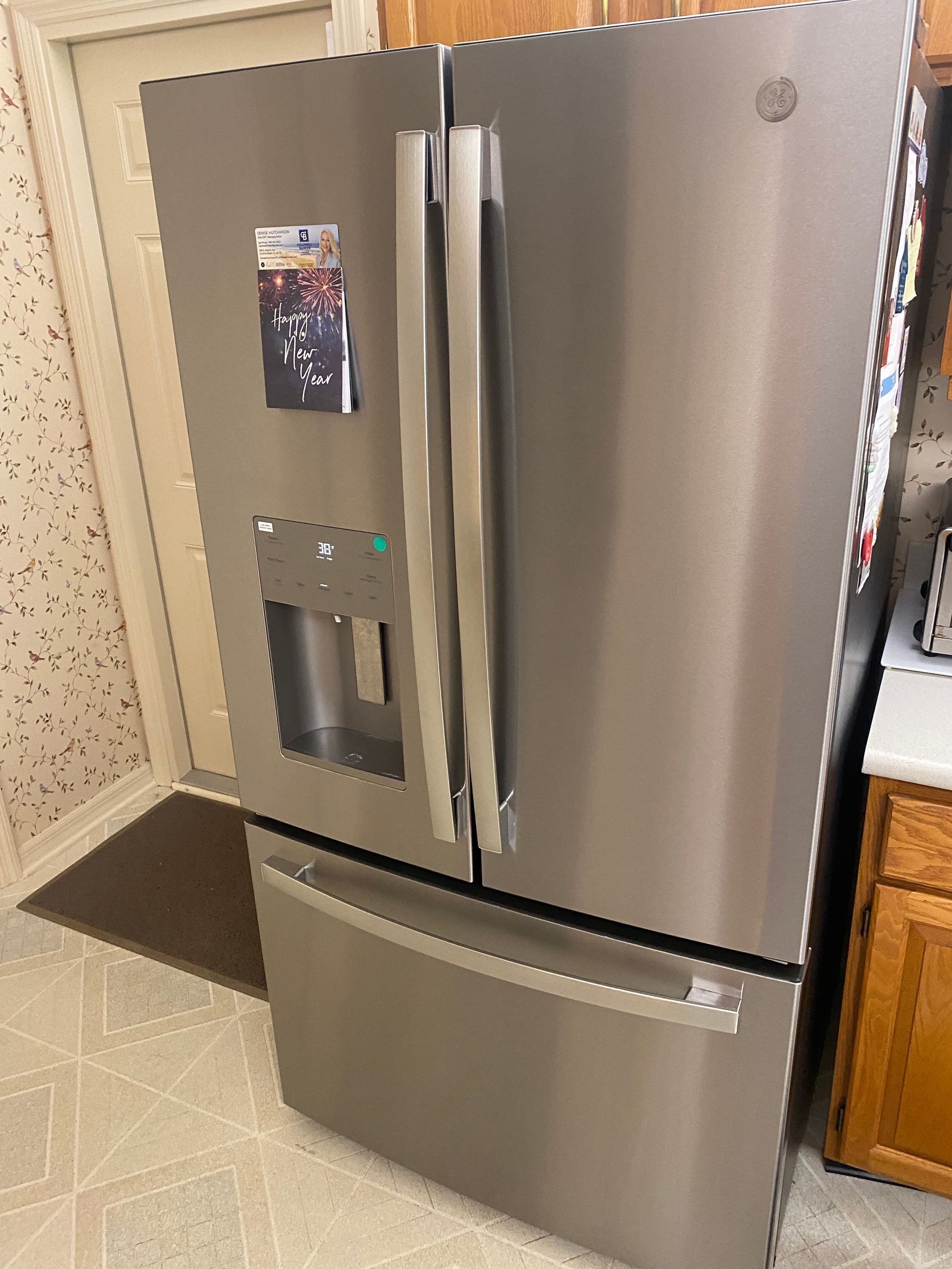 Stainless steel GE refrigerator with three doors, in a kitchen.