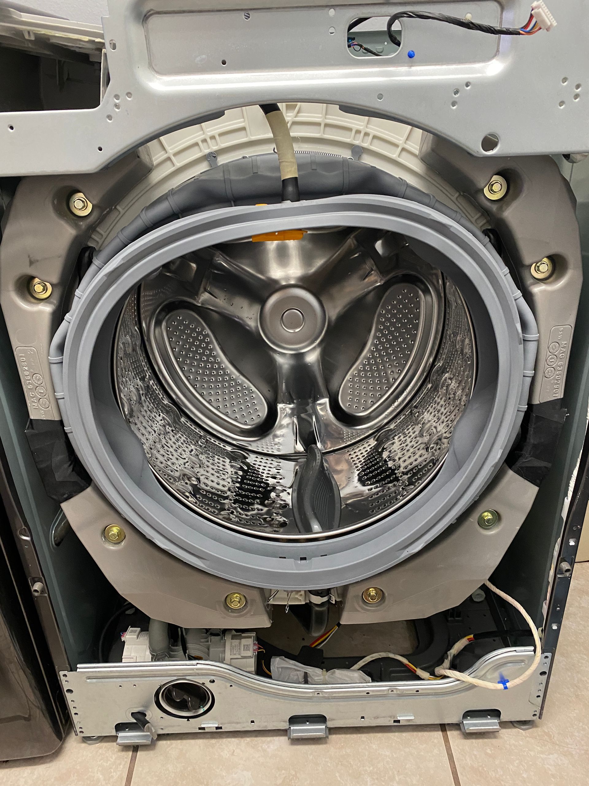 Open front of a washing machine. The drum and rubber seal are visible.