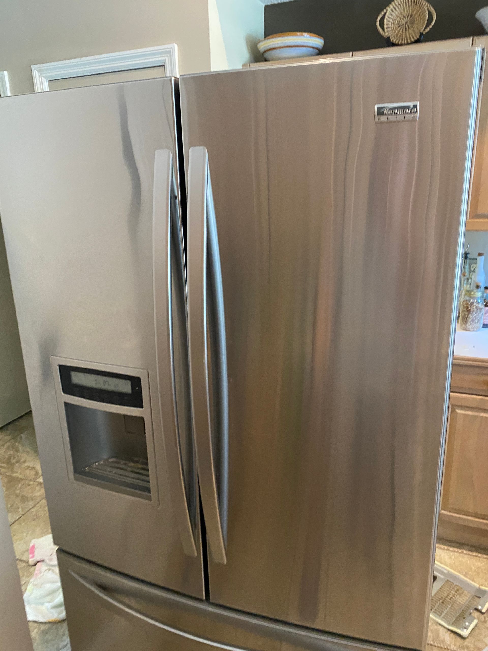 Stainless steel French door refrigerator in a kitchen.