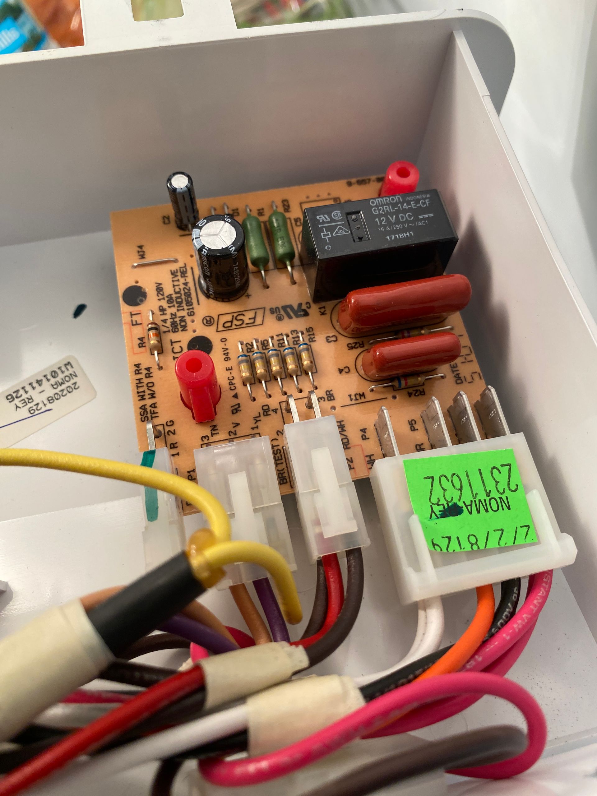 Printed circuit board with wiring in a white enclosure.