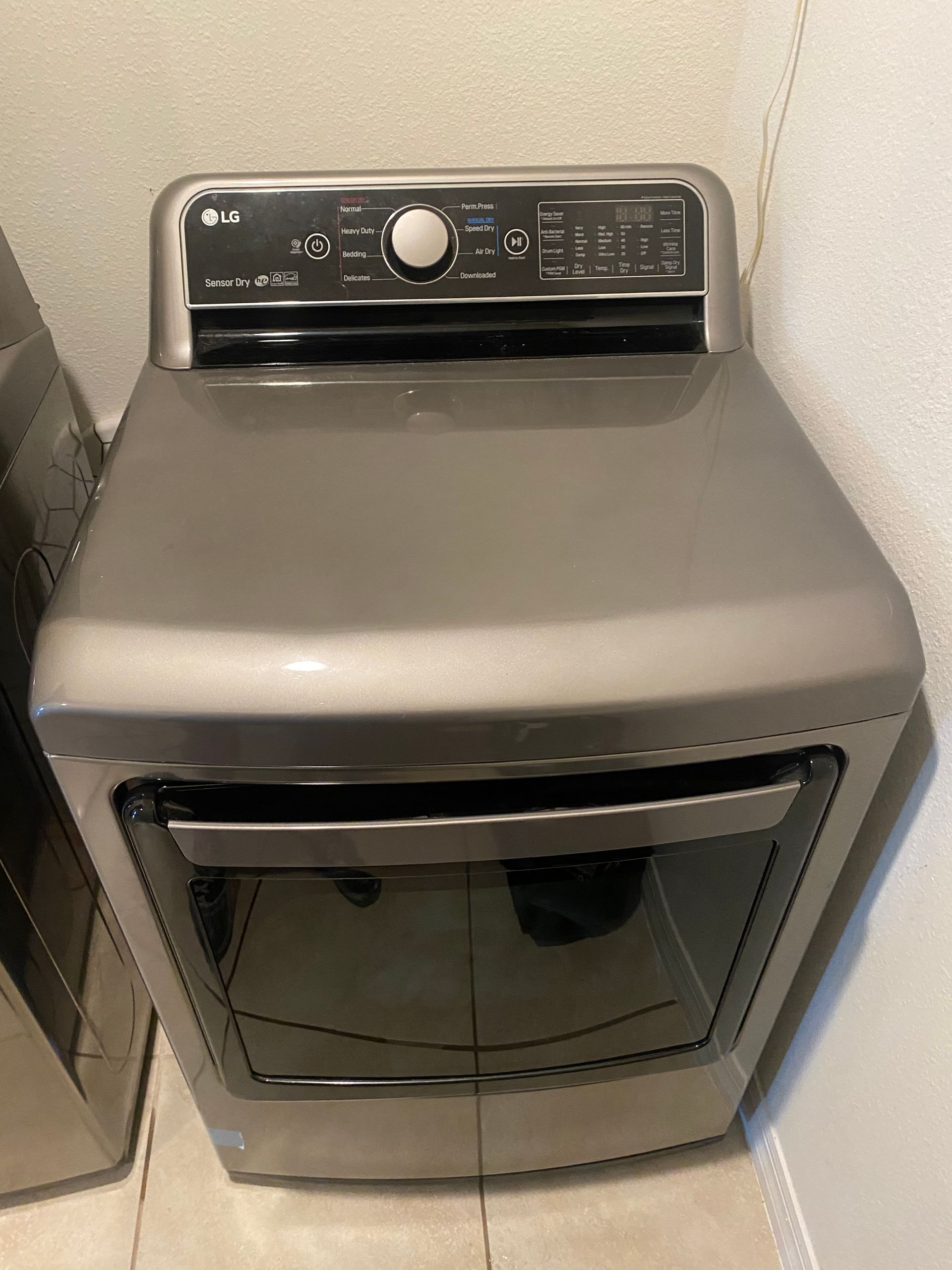 LG silver dryer with control panel on top and glass door.