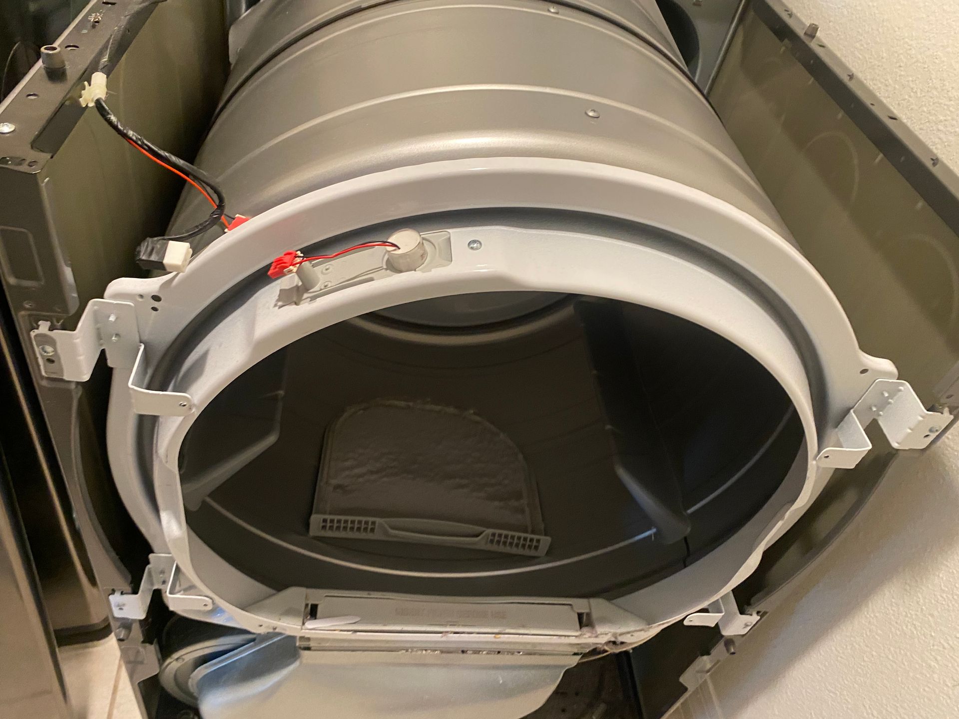 Open dryer drum with a gray drum and white trim.