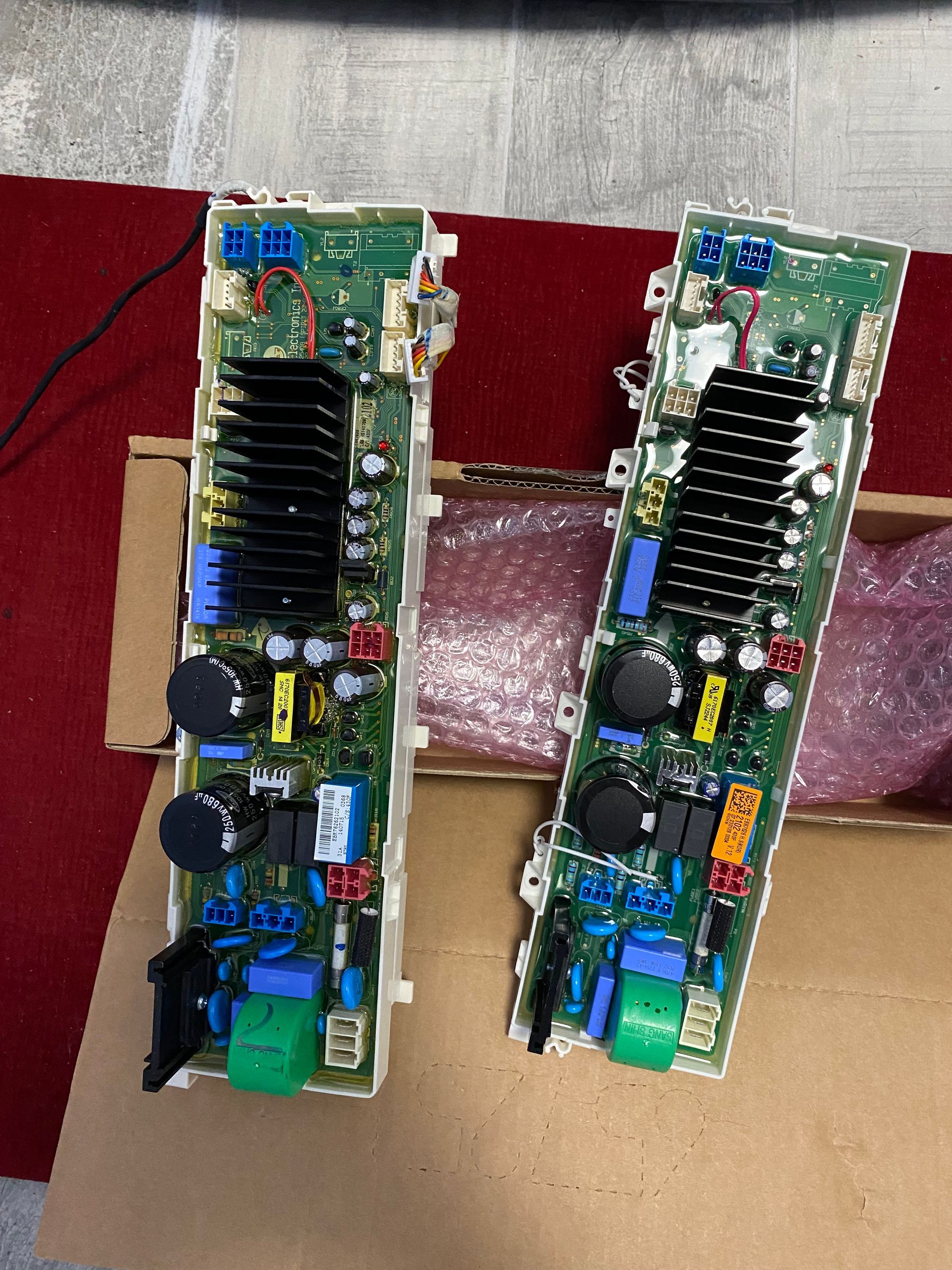 Two circuit boards with various electronic components, black heatsinks, and colored connectors.