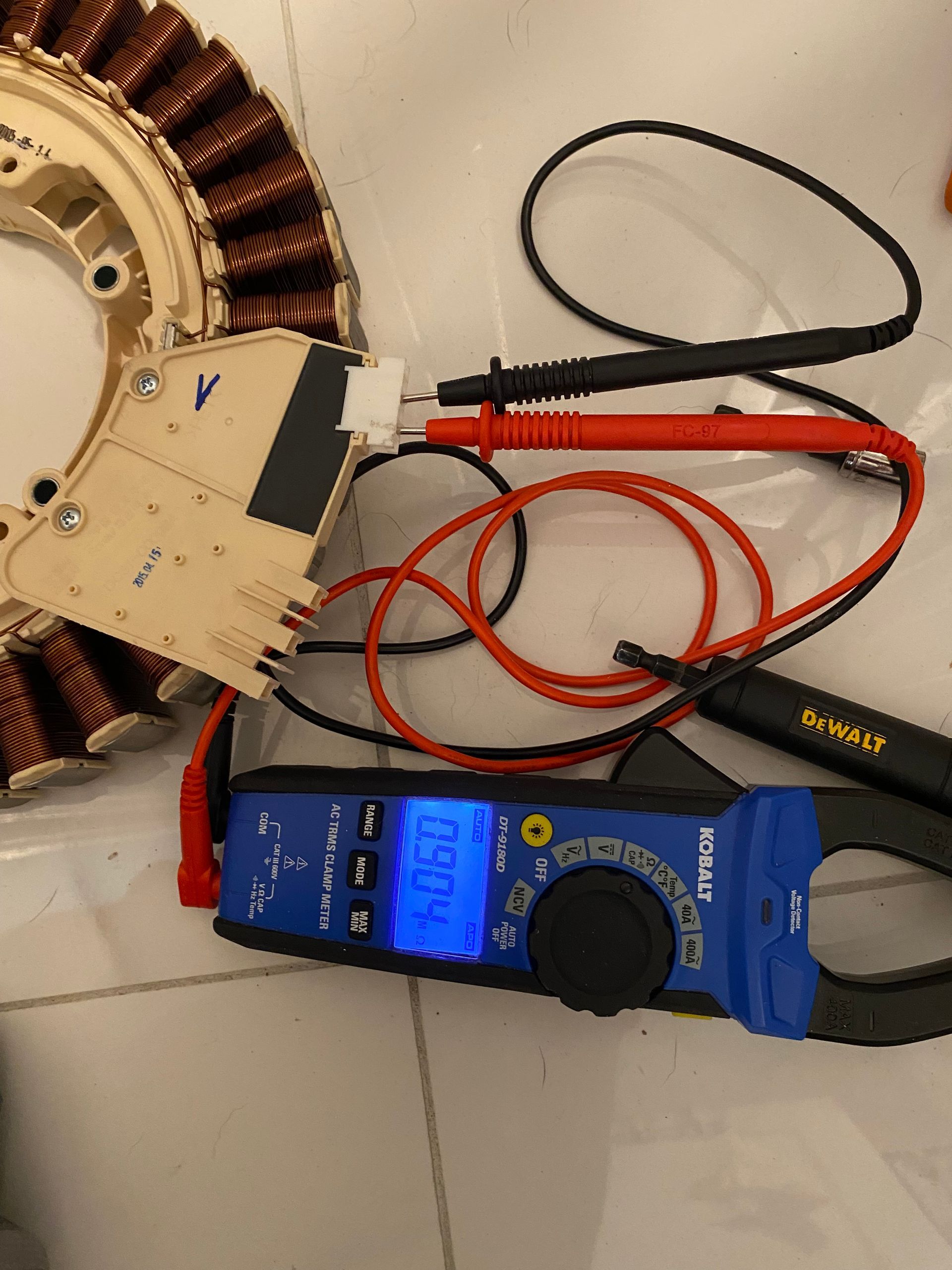 Multimeter measuring electrical component of washing machine. Red and black probes connected.