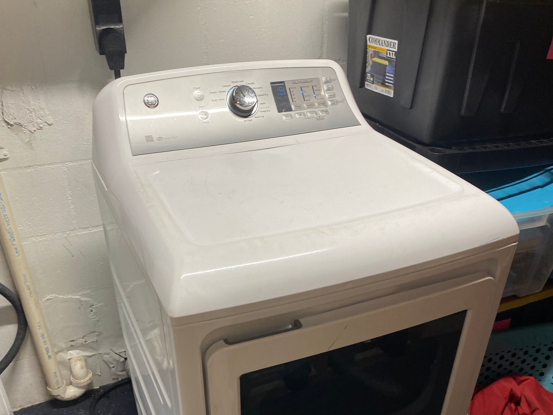 White GE dryer in a utility space.