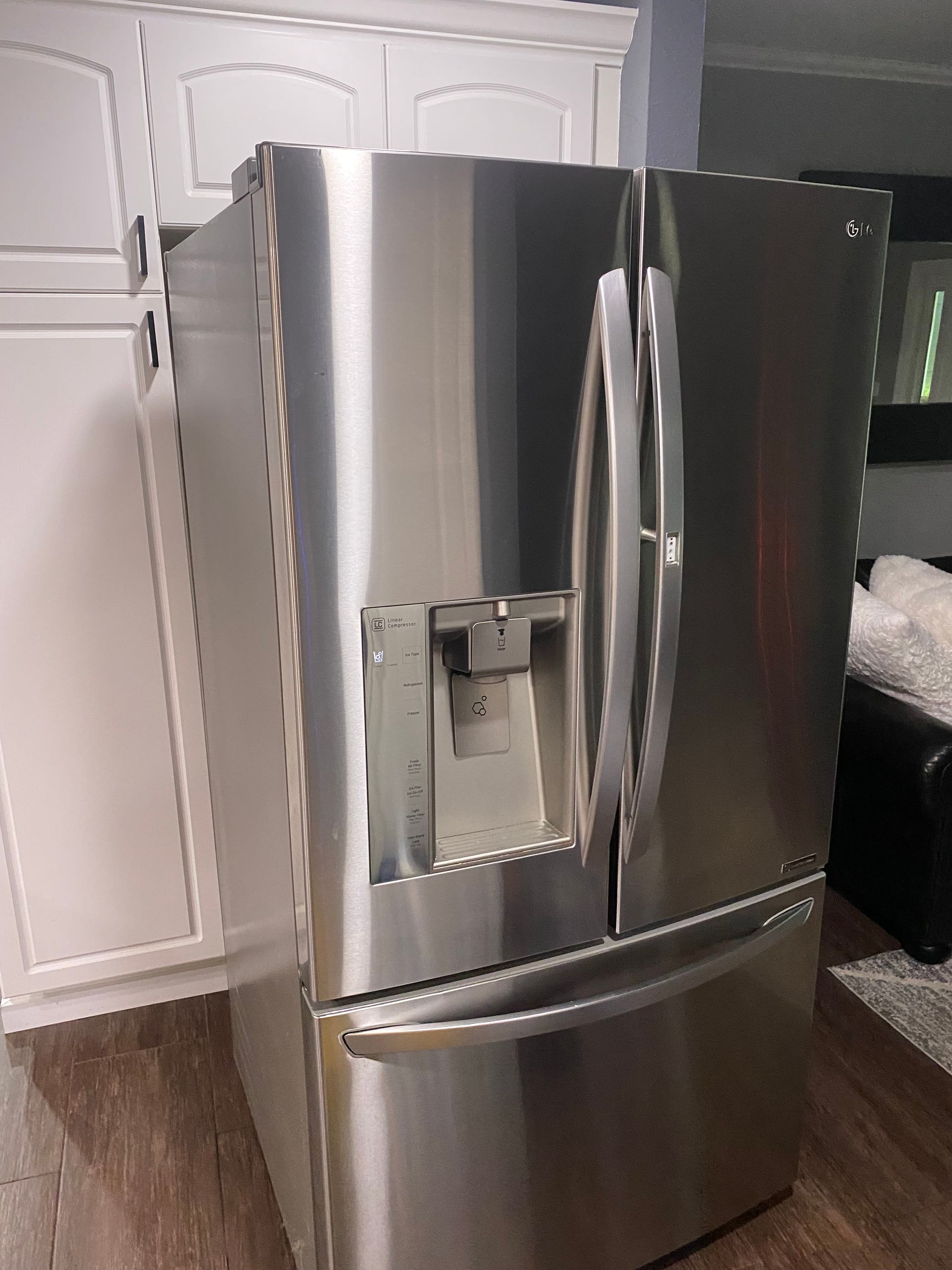Stainless steel LG French door refrigerator in a kitchen setting.