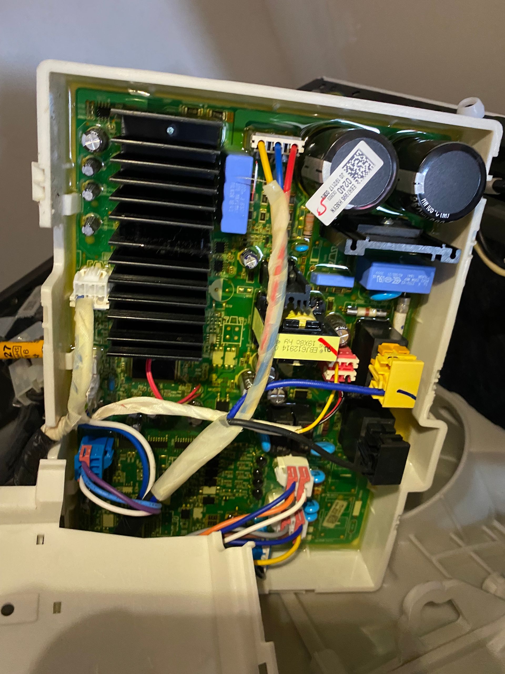 Circuit board with various colored wires and components inside a white plastic enclosure.