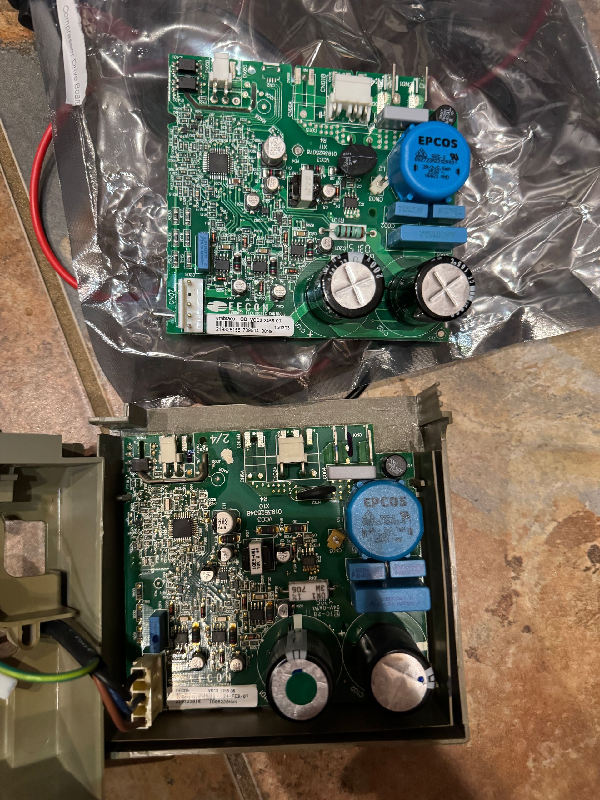 Two green circuit boards, one loose and one in a frame, with various electronic components.