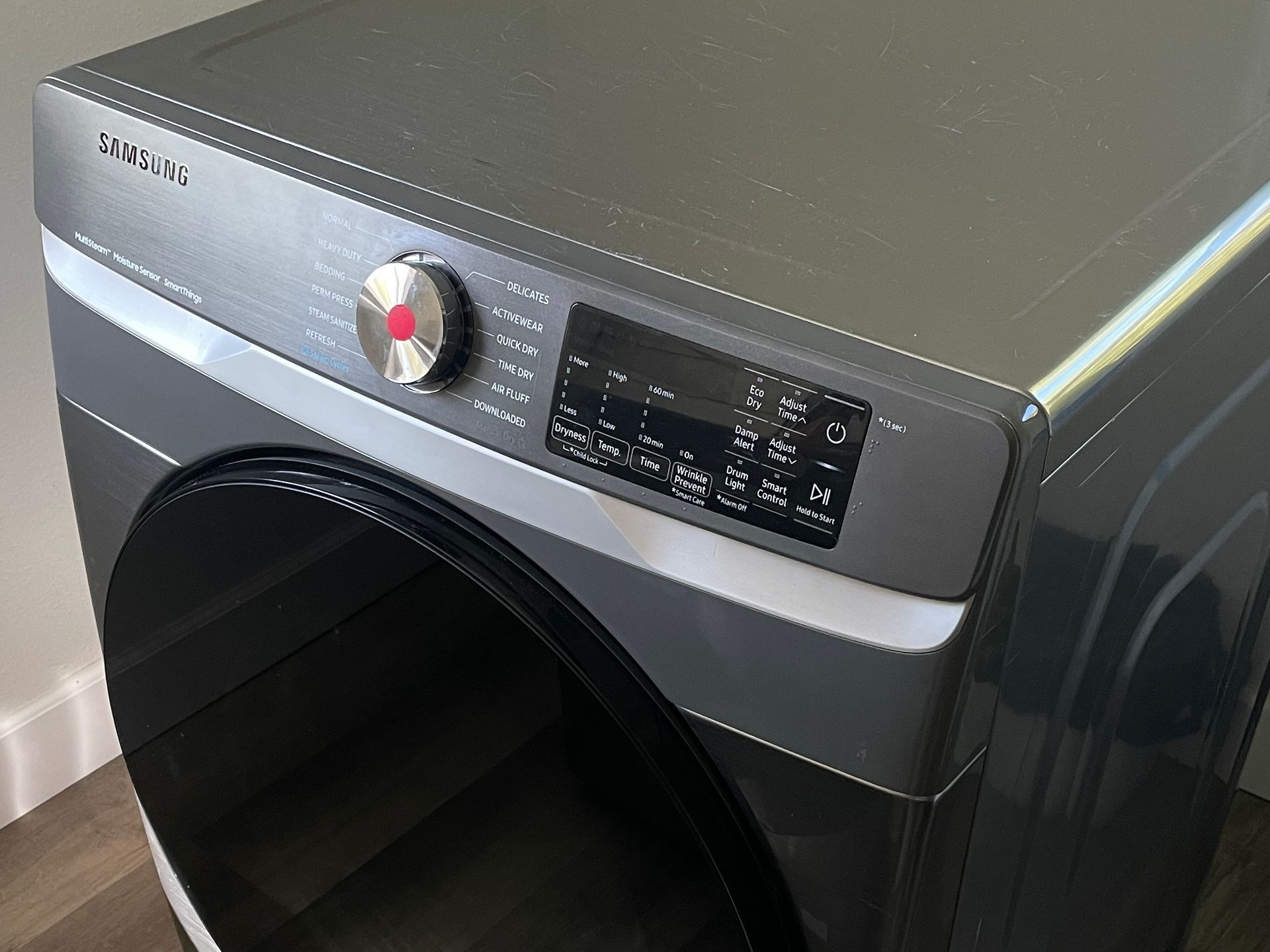 Samsung dryer with a dark door, silver and black body, and control panel.