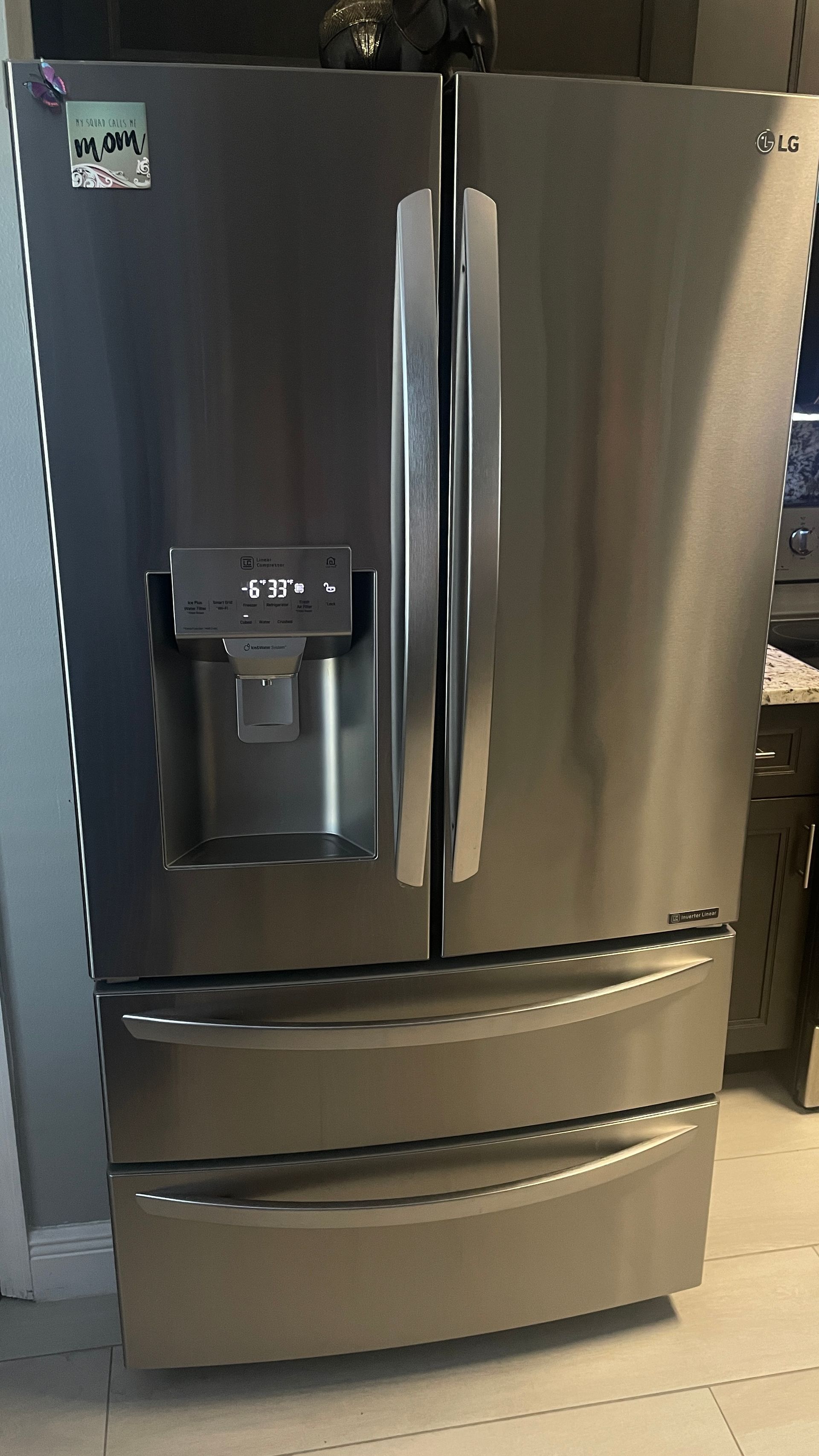 Stainless steel LG refrigerator with two doors on top and two bottom drawers.