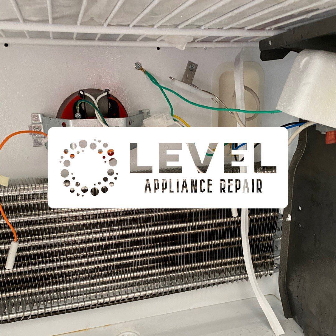Inside of a refrigerator, showing components like coils and wiring. White, silver, and green are visible.