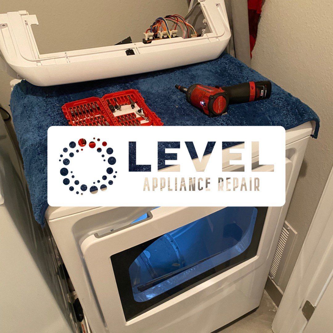 A dryer being repaired; the top is open, tools and logo visible.