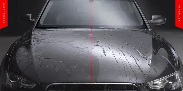 Black car hood with rainwater and a red vertical center line in a dark studio setting